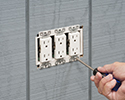 person installing receptacle into electrical box with box extender