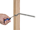 person installing cable support to wooden stud with screwdriver
