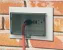 extension cord plugged into outdoor electrical box with cover closed