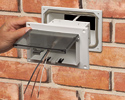 person sliding in-box into adapter sleeve installed on brick wall