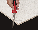 person cutting corner of ceiling tile with drywall saw