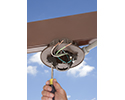 person installing fan bracket outdoors
