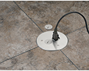 floor box in stone tiled floor with device plugged in