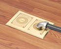 two gang floor box in wooden floor with 90 degree connector and conduit attached