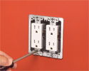 person installing receptacle in steel two gang box with screwdriver