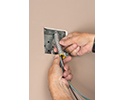 person twisting MC cable onto screw-in connector