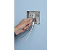 person sliding push-in connector over NM cable and into box